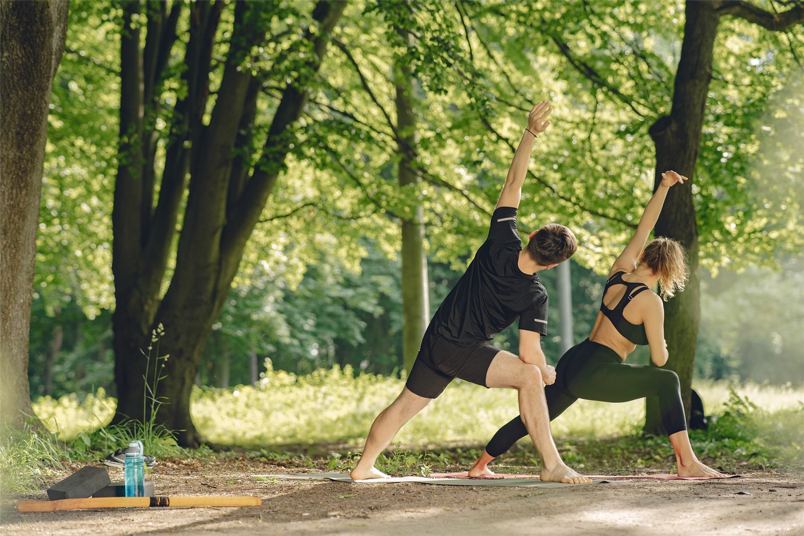 Two people stretching outdoors in a park