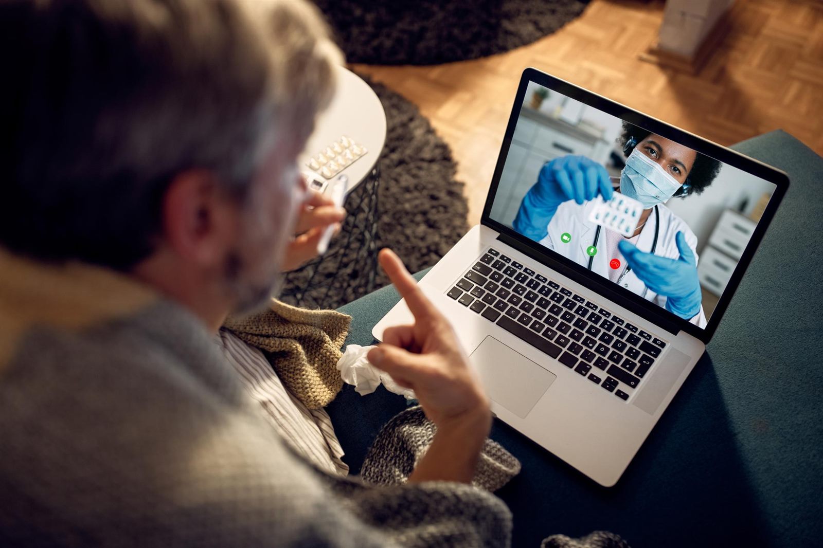 Patient on a telehealth video visit with a doctor on a laptop